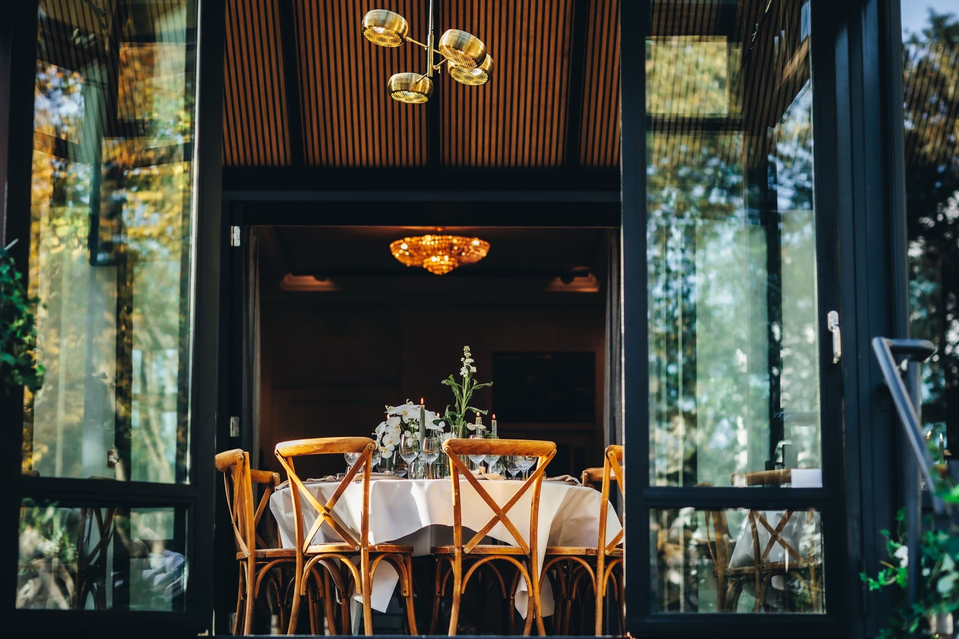 Diner in Villa 1855 met houten deurpartij en gouden kroonluchter