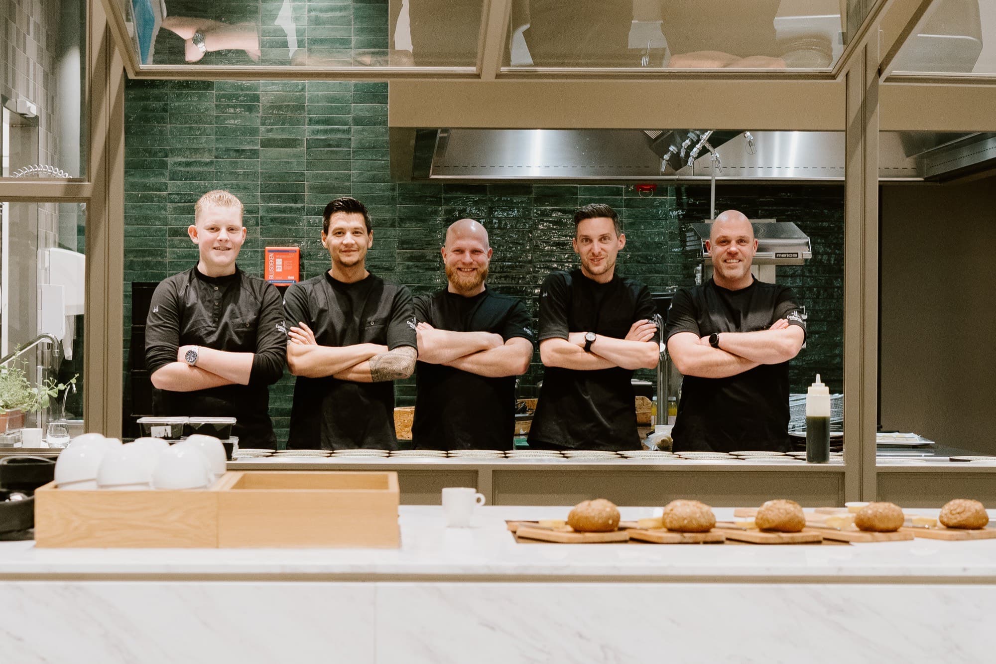 De keukenbrigade van Cookaholics in de open keuken van Villa 1855